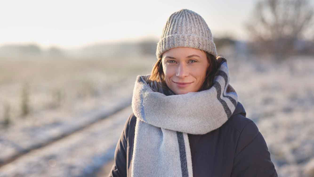 Femme en v&ecirc;tements d'hiver dans une nature enneig&eacute;e.